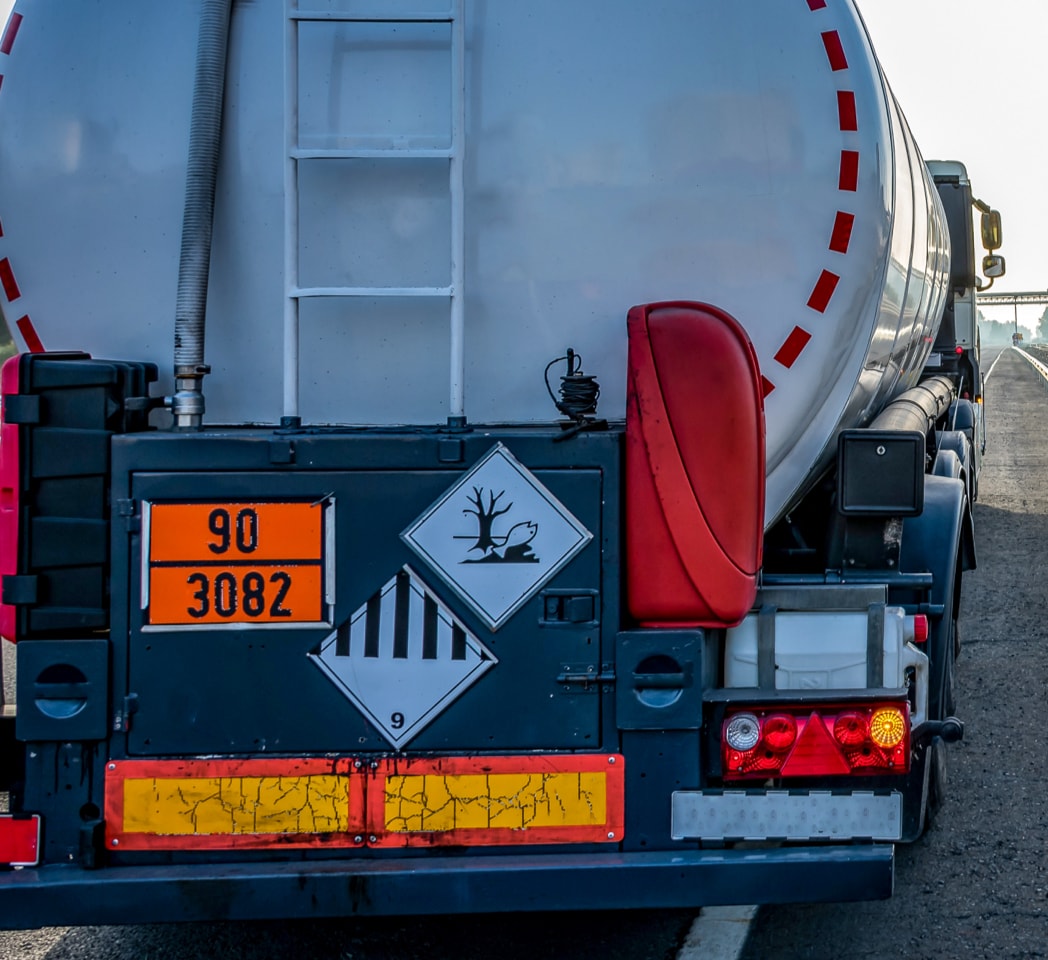 Ein wegfahrender Sattelzug-Lkw mit Gefahrenschildern